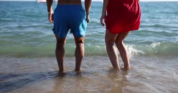 赤脚的男人和女人在沙滩上跳上空气 游客享受休息和浪漫假期的乐趣 — 图库视频影像