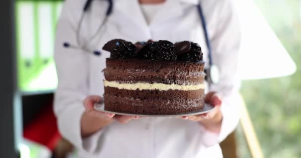高カロリーチョコレートケーキを保持栄養士の医師の手 体と健康のための甘いの害 — ストック動画