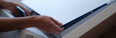 Tiflis, Georgia - 25 Mayıs 2022: Kadın yeni iMac monitöründen beyaz koruyucu filmi çıkardı. iMac Mi serisi yüksek kaliteli kişisel izleme konsepti