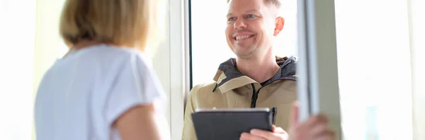 stock image Male courier delivering package and holding tablet with data. Parcel delivery service concept