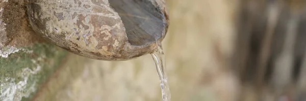 stock image Old stone and fountain with spring water flowing into pool. Antique water pipe made of stones concept