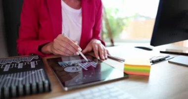 Pazarlamacı analist tablet üzerindeki analitik mali rapora ok atıyor. Analiz, istatistik ve kâr toplamları için mobil uygulamalar