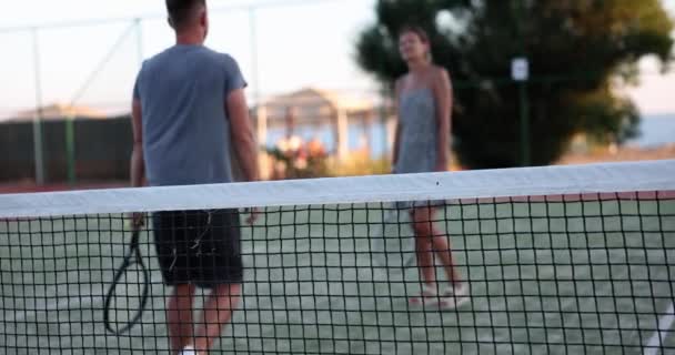 テニス選手のカップルは試合の終わりに互いに挨拶し テニスコートを離れる テニスゲームとライフスタイルのコンセプト — ストック動画