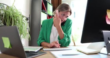 Meşgul yönetici müşteriye telefonda danışmanlık yapar, bilgisayardaki istatistiksel verileri yönetir. İş kadını, iş yerindeki iş yerinde birden fazla iş yapmakla meşgul.