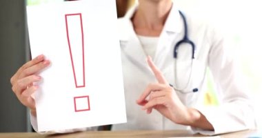 Doktor dikkat istiyor ve ünlem işareti tutuyor. Tıbbın ve ilginin gösterişli jesti