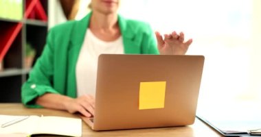 İş kadını ofisteki bilgisayarını kapatıyor. Çalışma gününün sonu