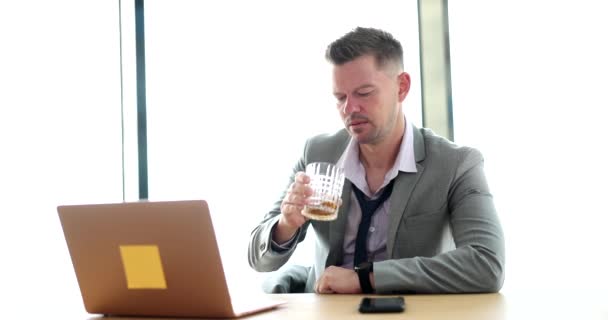 由于经济条件差 工作压力大 商人手里拿着威士忌 正在看笔记本电脑 工作场所的酗酒 — 图库视频影像
