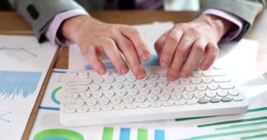 Bilgisayar klavyesinde yönetici tipleri ve grafik, analitik ve istatistik içeren belgeler. Stratejik planlama bankacılığı ve mali analist