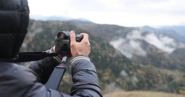 Erkek gazeteci profesyonel kamera 4K filmle doğanın fotoğraflarını çekiyor. Doğal manzara konsepti 