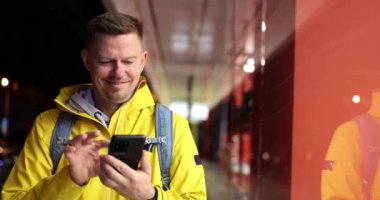 Cep telefonu uygulaması 4K yavaş çekim ile haritaya bakan genç adam. Cep telefonu navigasyon kavramı 