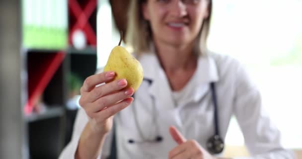 微笑着快乐的女医生拿着黄色的梨子 露出大拇指 营养学家烘焙水果医学概念与健康饮食 — 图库视频影像