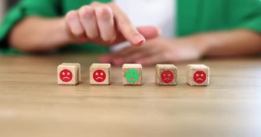 Yüzünde bir gülümseme olan tahta küpü elle seçmek en iyi iş hizmeti derecesi ve geri bildirim. Müşteri hizmetleri kalite değerlendirmesi ve memnuniyet anketi kavramı
