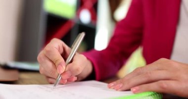 İş kadınlarının ellerinin kalem tutması, not defterine not alması ve test görevi yapması. Kadın girişimci önemli veri bilgileri ve yaratıcı başlangıç fikirleri kavramını yazar