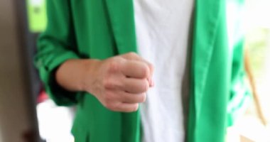 Takım elbiseli güçlü, kendine güvenen bir kadın yumruğunu sallıyor. Başarılı iş kadını kontrolü ve kariyeri