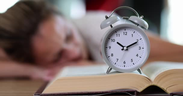Ξυπνητήρι Στο Βιβλίο Και Κοιμισμένη Κουρασμένη Γυναίκα Εκπαίδευση Χρόνος Μάθησης — Αρχείο Βίντεο