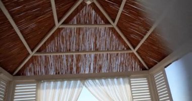 Çatısı sazdan beyaz tenteler. Deniz kıyısındaki kumlu tatil köylerinde yazlık lüks bungalovlar