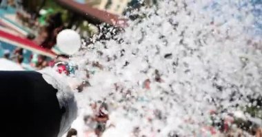 Kumsalda toptan köpük partisi. Havuzda turistler için eğlence