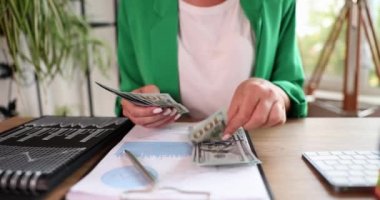 Kadın ofiste dolar banknotları sayıyor. Finansal başarı ve iş kavramı