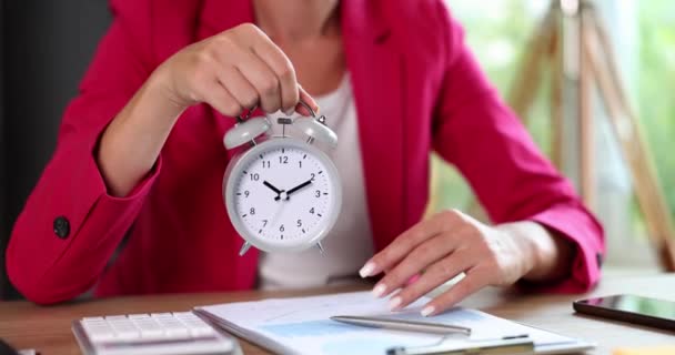 職場で目覚まし時計を持っているビジネス女性 時間管理と個人の効率性の概念 — ストック動画