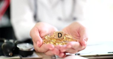 D vitamini kapsüllü kadın beslenme uzmanı elleri. Doktor diyet kliniğinde ilaç ve vitamin reçetesi yazıyor.