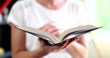 Kadın kitap okurken sayfayı çeviriyor. Ev hobileri eğitim anlayışı ve kitap okuma