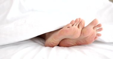 Kadının yaklaşması yatakta bacakları sendeler. Yatakta bacaklarını esnet.