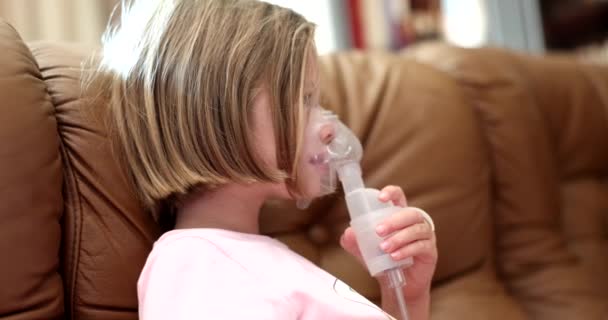 ソファで自宅でNebulizerを使用して医療用酸素マスクの病気の女の子 小児の治療における吸入性ネブライザー — ストック動画