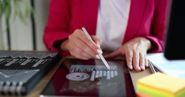 Ofisteki bir kadın tablette stilus kullanıyor, yakın plan. Dijital bir uygulamada veri analizi