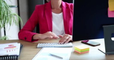 Ofiste oturan iş kadını elini sallıyor, yakın plan, yavaş çekim. Merhaba jest ve elveda.