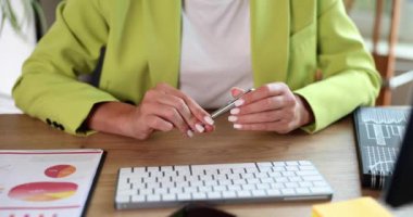 Ofiste oturan bir kadın elinde bir kalem tutuyor, yakın plan. Bilgi hakkında düşünmek için kavram