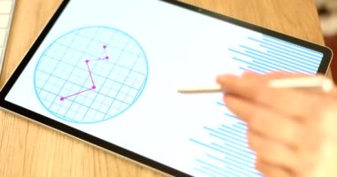 Stylus yapraklı el tabletteki raporları inceliyor, yakın plan. Finansörün işi için araçlar