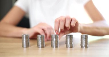 Ahşap masada eşit miktarda gümüş para var, yakın plan. Düzenli katkı payı, kredi faizi, ipotek