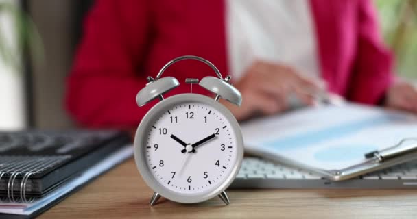 オフィスでは テーブルの上に灰色の目覚まし時計 クローズアップ ビジネスにおける時間の概念 用語の遵守 作業負荷 — ストック動画