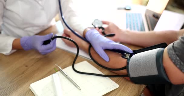 診療所の医師は人の圧力を測定し 手を閉じています 血圧を監視する医療機器 — ストック動画
