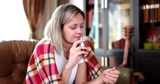 一个坐在沙发上的女人用鼻腔喷雾器 一个特写 慢动作 新月治疗 流鼻涕 — 图库视频影像
