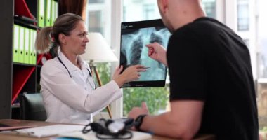 Kadın, bir adamla akciğerlerinin röntgenini çekiyor. Yakın plan. Hastalığın teşhisi