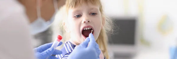 穿着防护服的实验室助理的肖像包括儿童喉咙的擦拭 家中的程序 围观概念 — 图库照片
