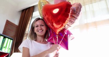 Renkli balonları olan neşeli, güzel ve çekici genç bir kadının portresi. Tatil ve parti