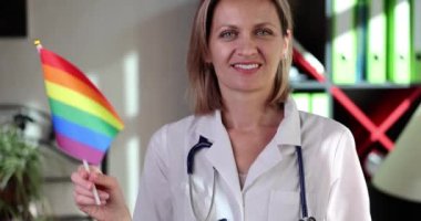 Gökkuşağı bayrağı taşıyan güzel bir kadın doktor. Biseksüel lezbiyen ve transseksüel bakım konsepti