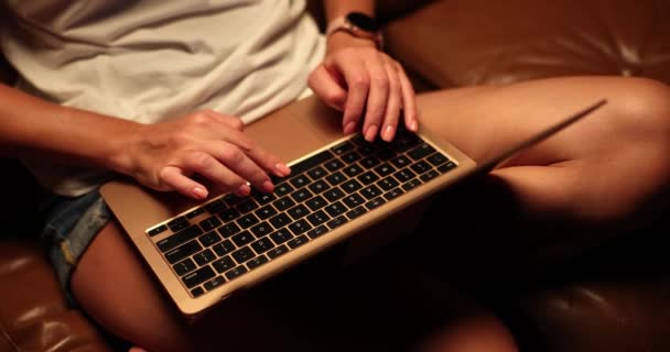 光着身子在笔记本电脑上工作的女人坐在沙发上 女孩在夜间靠近键盘和触摸板时使用笔记本电脑 — 图库视频影像