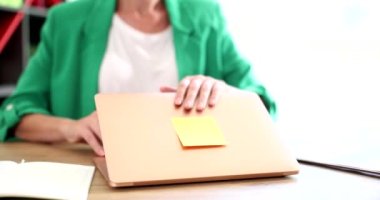 İş kadını yönetici sekreteri bilgisayarı kapatıyor ve mesaisi bitiyor. Fazla mesai ve çevrimiçi zaman denetimi