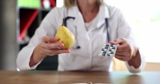 Médico Nutricionista Detém Pêra Amarela Com Medicamentos Closeup Conceito Escolha — Vídeo de Stock