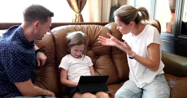 爸爸妈妈用平板电脑骂孩子 孩子沉浸在网络游戏中 儿童忽视父母和抚养 — 图库视频影像