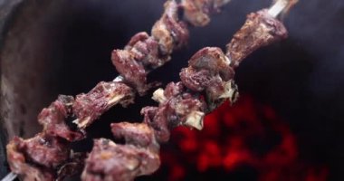 Şişlerin üstünde leziz iştah açıcı kebaplar. Yakın çekim 4K film yavaş çekim. Barbekü konseptiyle dışarıda tatil.