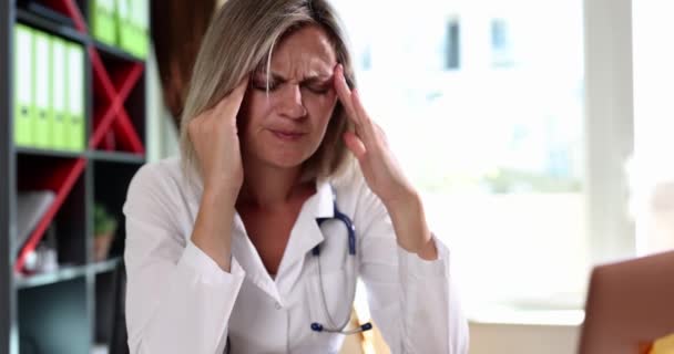 Donna Medico Massaggiare Templi Alla Scrivania Clinica Film Slow Motion — Video Stock