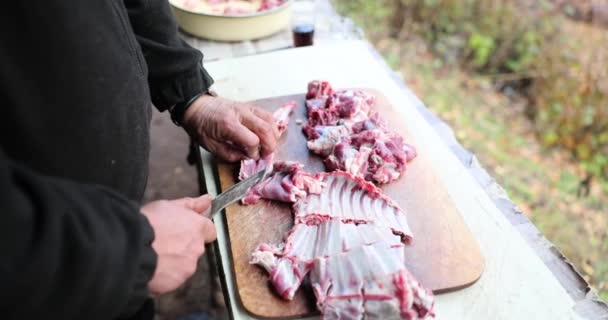 男性の手はバーベキューのためにまな板に肉を切った 肉肋骨の準備 — ストック動画