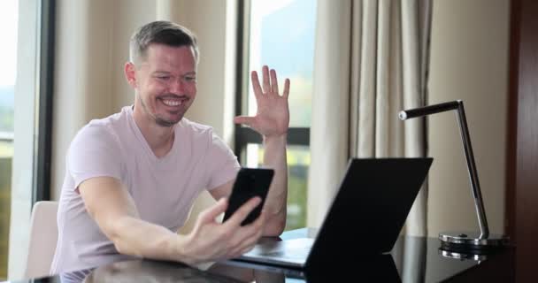 快乐的男人正在用手机进行视频通话和显示大拇指 自由撰稿人在网上谈笑风生 — 图库视频影像