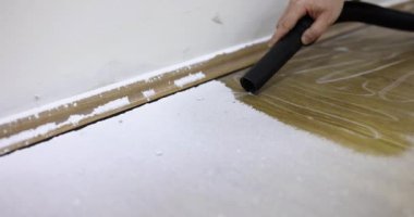 Usta tamirci inşaat süpürgesiyle toz topluyor. Yakın çekim 4K film yavaş çekim. Tamir konsepti için ev aletlerinin satışı