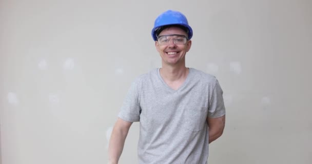 Constructor Masculino Casco Apuntando Pared Con Yeso Sonriente Película Cámara — Vídeos de Stock