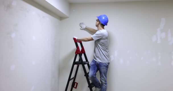 男工在头盔检查质量应用石膏墙壁和显示还好的姿态4K电影慢动作 公寓概念的高质量维修和装修 — 图库视频影像